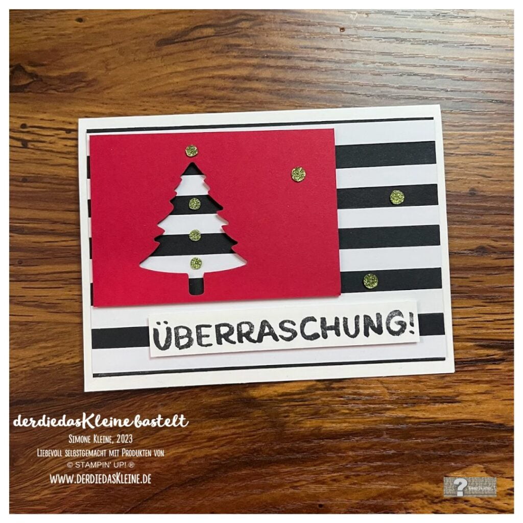 schwarz-weiß-rote Karte im Streifendesign mit Überraschung!
Aus rotem Karton ist die Silhouette eines Tannenbaums ausgestanzt. 